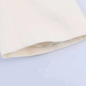 Macro shot of ivory linen blazer sleeve showing detailed fabric texture and lining