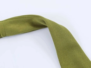 Detailed macro view of the bright green pleated knit fabric with textured grain