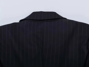 Macro detail of the back collar and shoulder stitching on a pinstripe blazer jacket