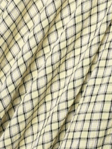 Detailed macro view of yellow plaid seersucker fabric texture for summer midi dress