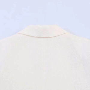 Close-up of the collar and neckline texture on a white linen blend blazer jacket