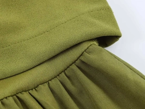Detailed macro view of olive green pleated fabric texture and professional stitching seams