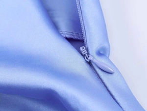 Detail des hochwertigen blauen Satinstoffs und nahtloser Reißverschluss an dem Kleid
