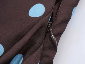 Detail view of the seamless invisible zipper on coffee dress with blue polka dots