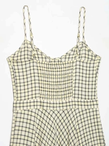 Close-up of smocked back detail on a yellow plaid midi dress with adjustable straps