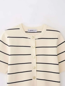 Détail du cardigan en maille rayée avec boutons dorés ornementés et col rond