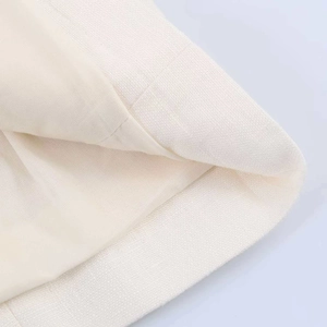 Detail of white linen blazer showing textured fabric weave and smooth inner lining