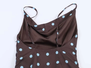 Detail of a dark brown summer dress with large blue dots and adjustable spaghetti straps