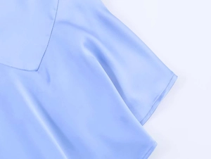 Detailaufnahme des hellblauen Satinkleids mit glatter Textur und seidigem Glanz
