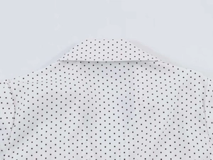 Close-up of white shirt collar with black polka dot print in soft cotton fabric