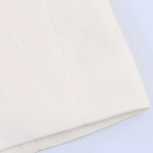 Detailed macro view of high-quality white linen fabric and fine stitching on the blazer