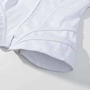 Detailed close-up of white twill denim jacket showing intricate structural stitching and hem
