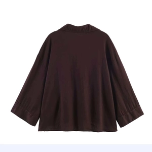 Detailed back view of a loose dark brown corduroy long-sleeve shirt with spread collar