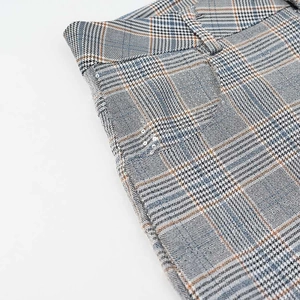 Detailed view of plaid trousers with silver rhinestone studs on pocket edge