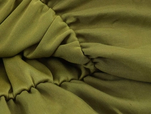 Detail shot of olive green pleated knit fabric showing stretch texture and fine stitching