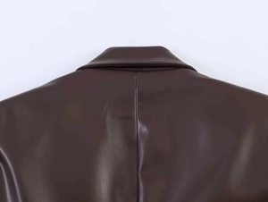 Detail of the stitching and high-quality leather texture on dark brown PU blazer jacket