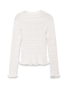 Close-up of white smocked knit cardigan featuring elasticated texture and ruffled edges