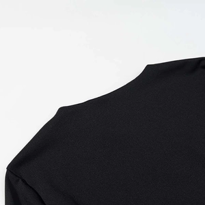 Dettaglio del top nero slim-fit con tessuto strutturato e cuciture rifinite sulla spalla