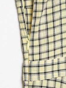 Detailed macro view of the invisible side zipper on yellow and black checkered dress