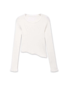 Detail shot of the white ribbed knit top featuring a unique asymmetric wave hemline