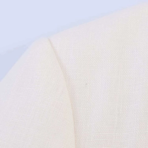 Detailed macro view of white linen blazer fabric showing natural woven texture and stitching