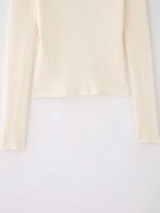 Détail du cardigan en maille côtelée crème montrant la texture fine et les finitions