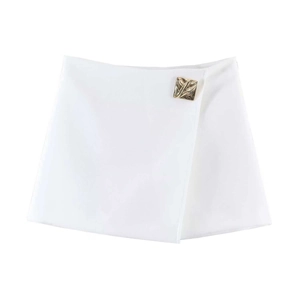Detail view of white wrap skirt featuring a decorative gold textured metal buckle