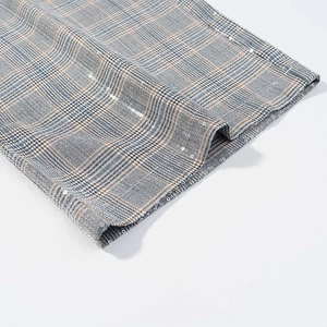 Close-up of grey plaid fabric with blue and brown checks and subtle sequin details