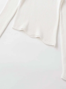 Detailed macro view of the wavy lettuce hem and ribbed knit texture on a white sleeve