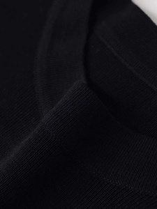 Detailansicht aus nächster Nähe von schwarzem Strickstoff mit feiner Rippenstruktur und Naht