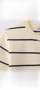 Détail d'un haut en maille rayé beige et noir montrant le col et la texture douce