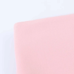 Detailed macro view of soft pink high-waisted skirt fabric texture and knit weave