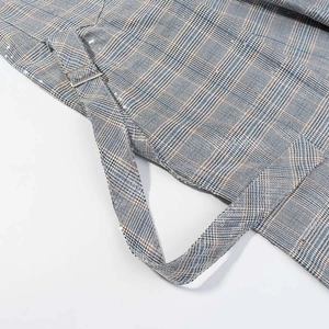Close-up of Prince of Wales check fabric with subtle sequins and silver metal buckle detail