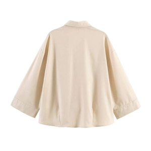 Detailed back view of a minimalist beige loose-fit long sleeve shirt with neat stitching