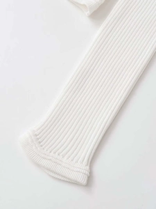 Detailed macro view of white ribbed knit fabric and long sleeve cuff texture