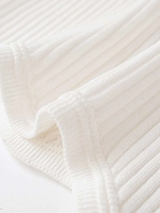 Close-up of white ribbed knit fabric showing detailed stitching and premium texture