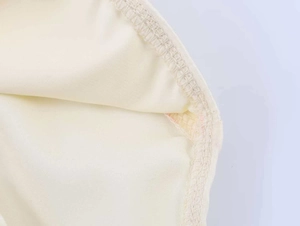 Dettaglio delle cuciture precise e dei bordi interni del body in raso e pizzo