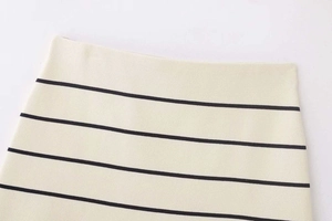 Détail de la mini-jupe en maille à rayures montrant la texture du tissu et la taille