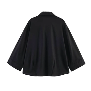 Back view of black loose-fit minimalist shirt with turn-down collar and wide sleeves