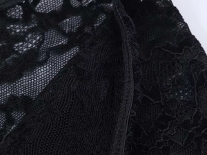 Gros plan sur un tissu en dentelle florale noire avec des motifs de maille détaillés