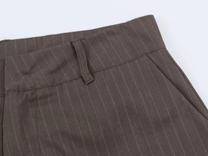 Detail of waist design on dark brown striped trousers showing belt loops and side pockets