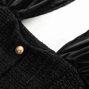 Detail of tweed fabric with silver thread and golden button on puff sleeve top