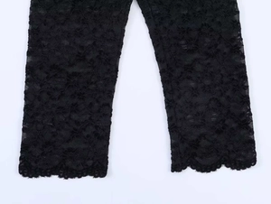 Vue détaillée de la dentelle florale noire avec bord festonné et texture en maille
