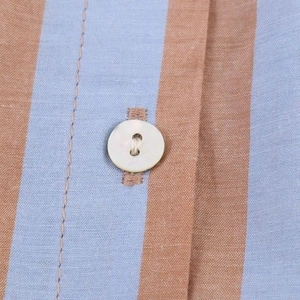 Detail of blue and brown striped shirt fabric with a polished white button