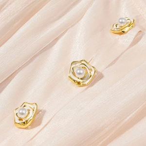 Gros plan de boutons camélia élégants avec perles sur la robe d'été plissée