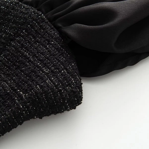 Macro detail of black tweed fabric with metallic yarn and smooth satin contrast