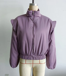 Detailed macro shot of lavender short jacket featuring ruffled shoulders and stand-up collar