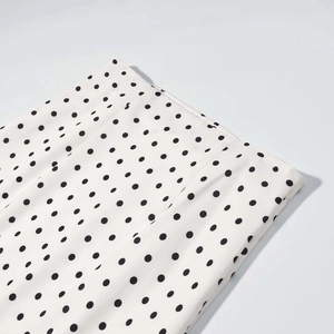 Détail du tissu tissé blanc avec imprimé classique à motifs de pois noirs