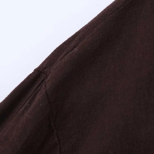 Detail shot of the shoulder seam on a dark brown knit shirt with dense fabric texture