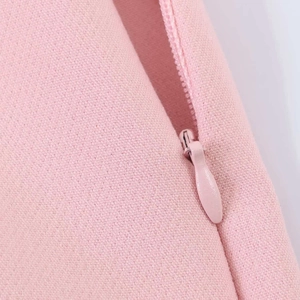 Detail of pink skirt showing invisible side zipper and textured polyester fabric weave